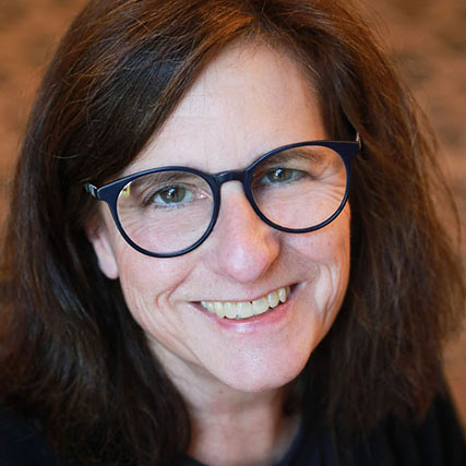 Woman with brown hair and black glasses