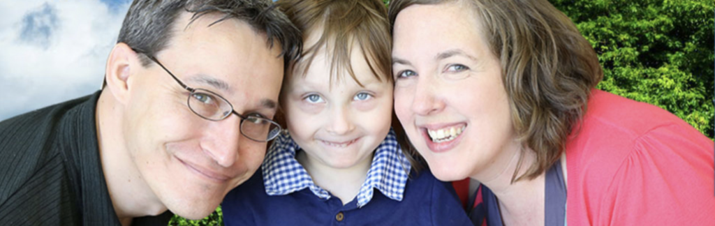 Mom and dad on each side son, he is about 4 years old and everyone is smiling into the camera.