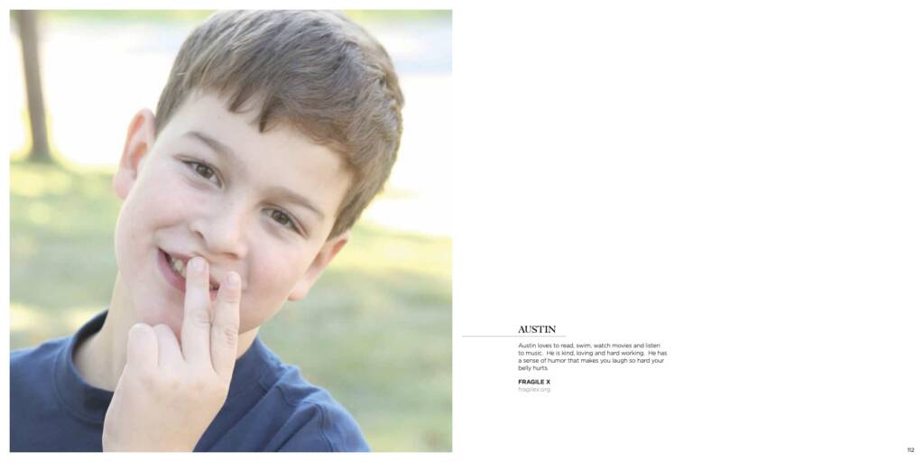 Young boy smiling into the camera with his fingers on his lips.