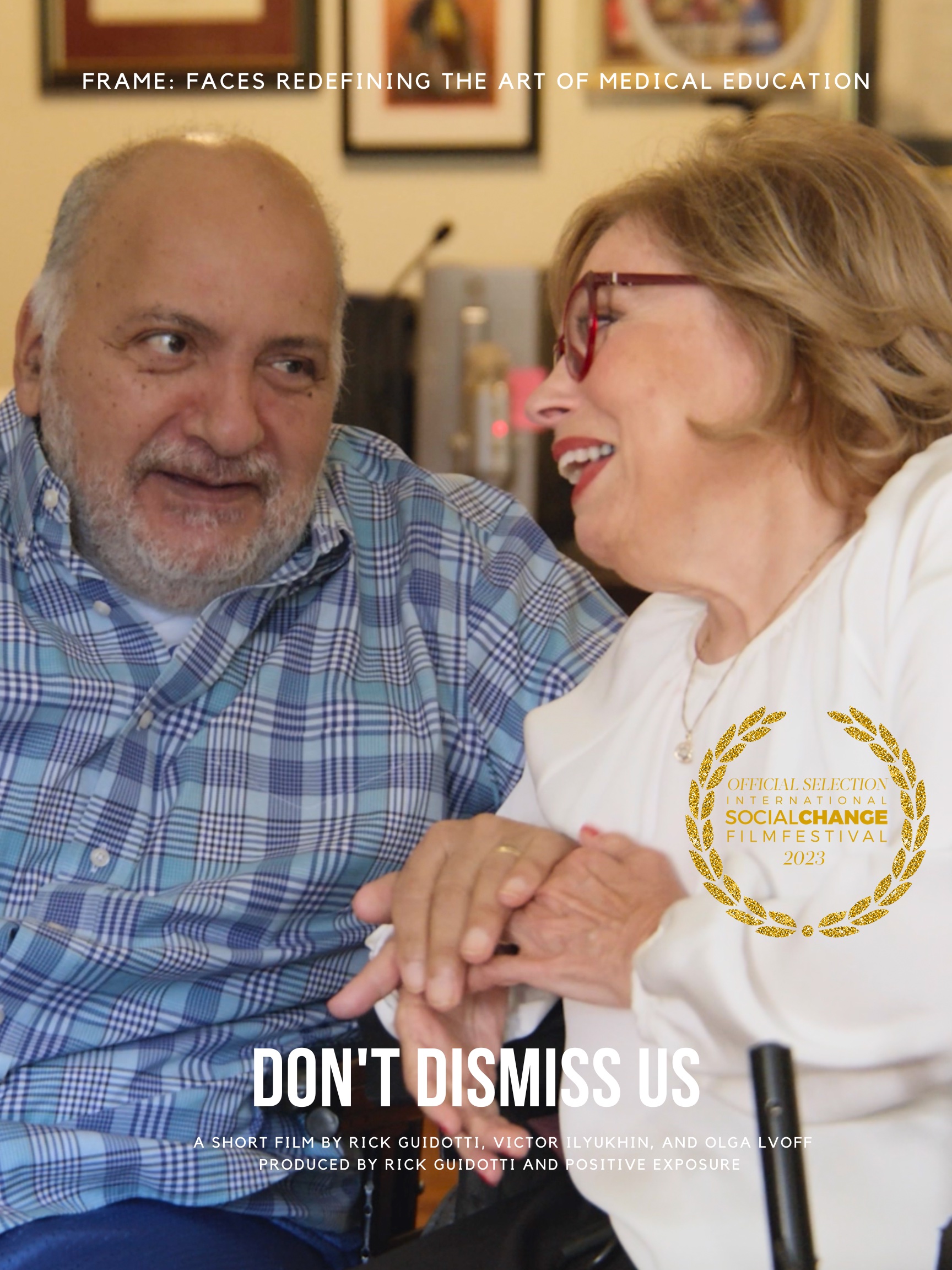 Movie Poster Image Description: Older man and woman holding hands and looking into each others eyes affectionately. At the top The top of the image reads Faces Redefining The Art Of Medical Education. Mid image on the right is a Film festival laurel:Official Selection International Social Change Film Festival 2023 in gold lettering. At the bottom in large white letters, Don’t Dismiss Us with smaller text below, A Short Film by Rick Guidotti, Victor Ilyukhin and Olga Lvoff Produced by Rick Guidotti and Positive Exposure.