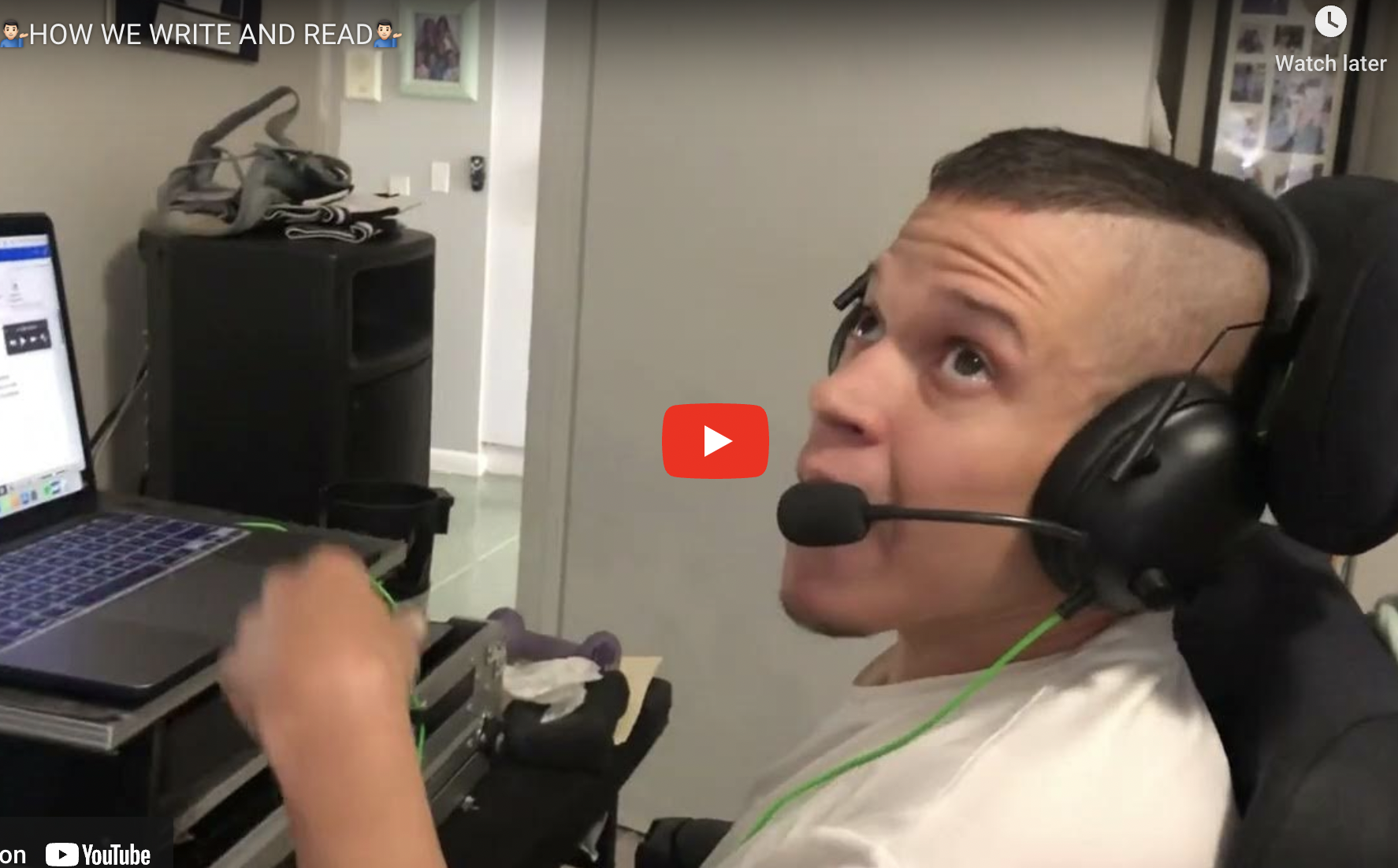 Yung man in wheelchair in front of computer with heardset on.