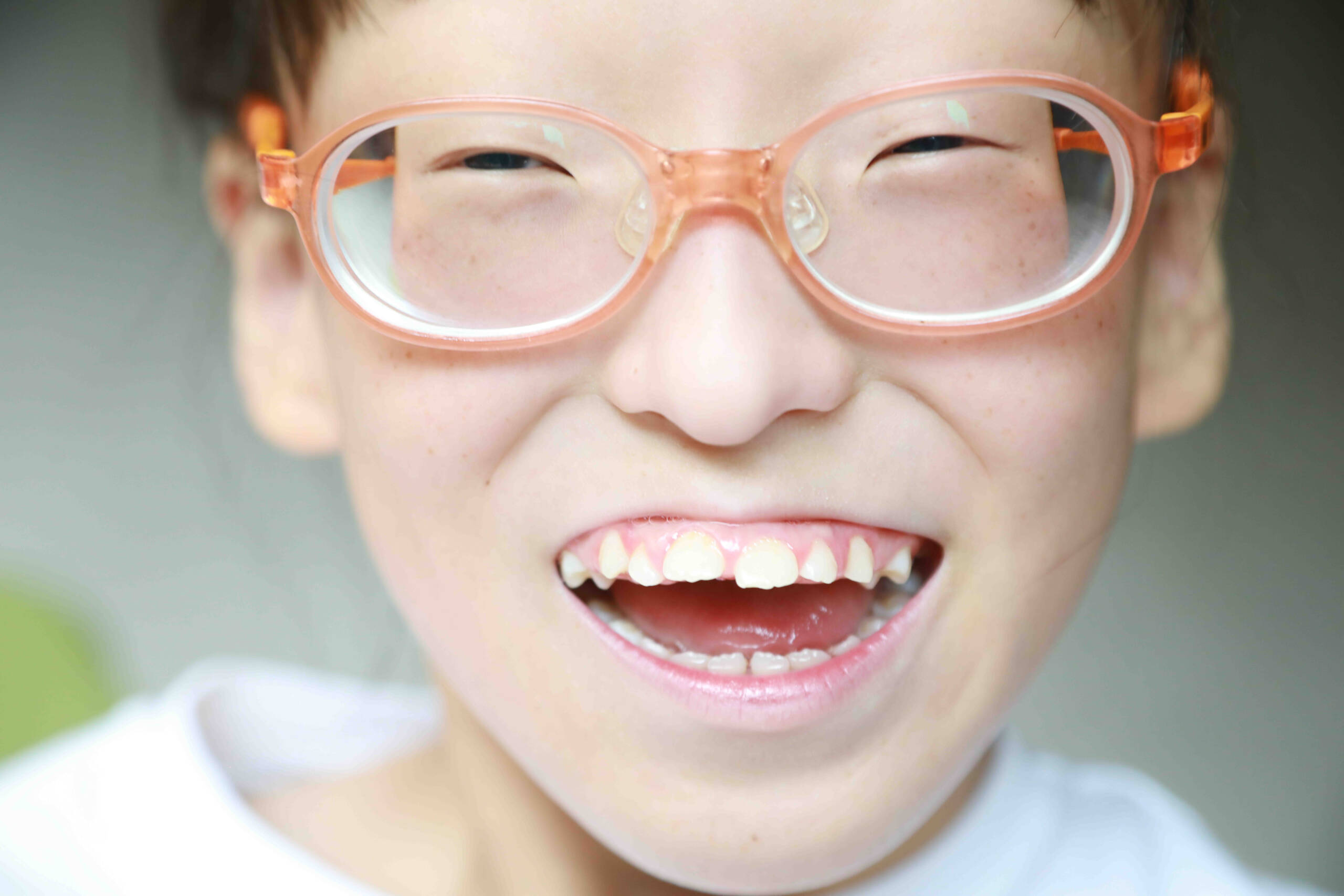 Young girl smiling with orange glasses