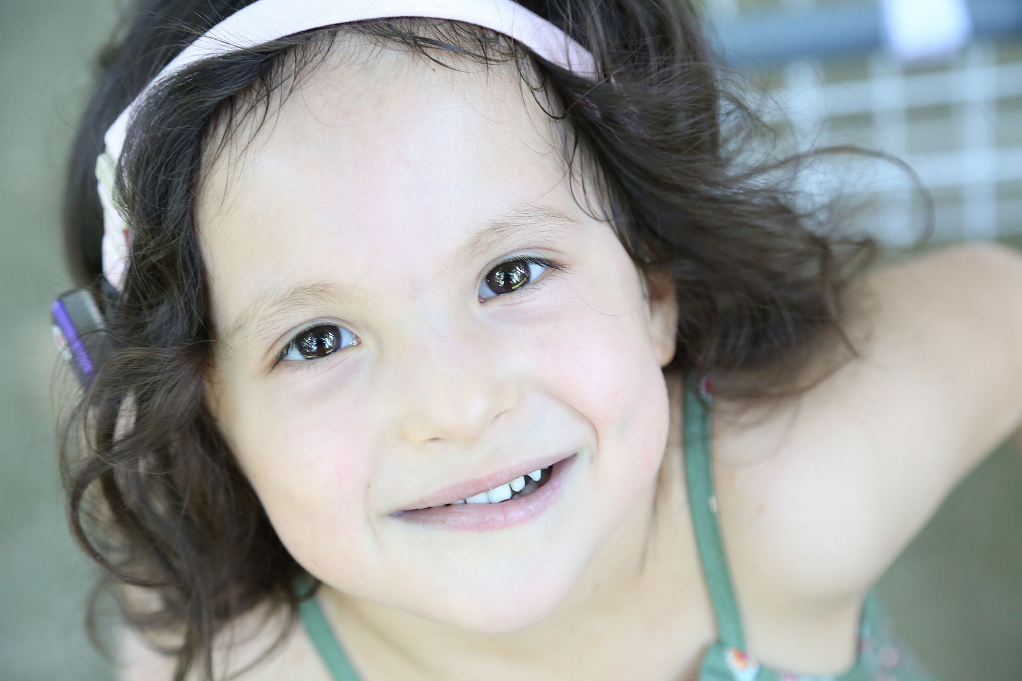 Girl with sacral agenesis caudal regression looks up into camera, smiling