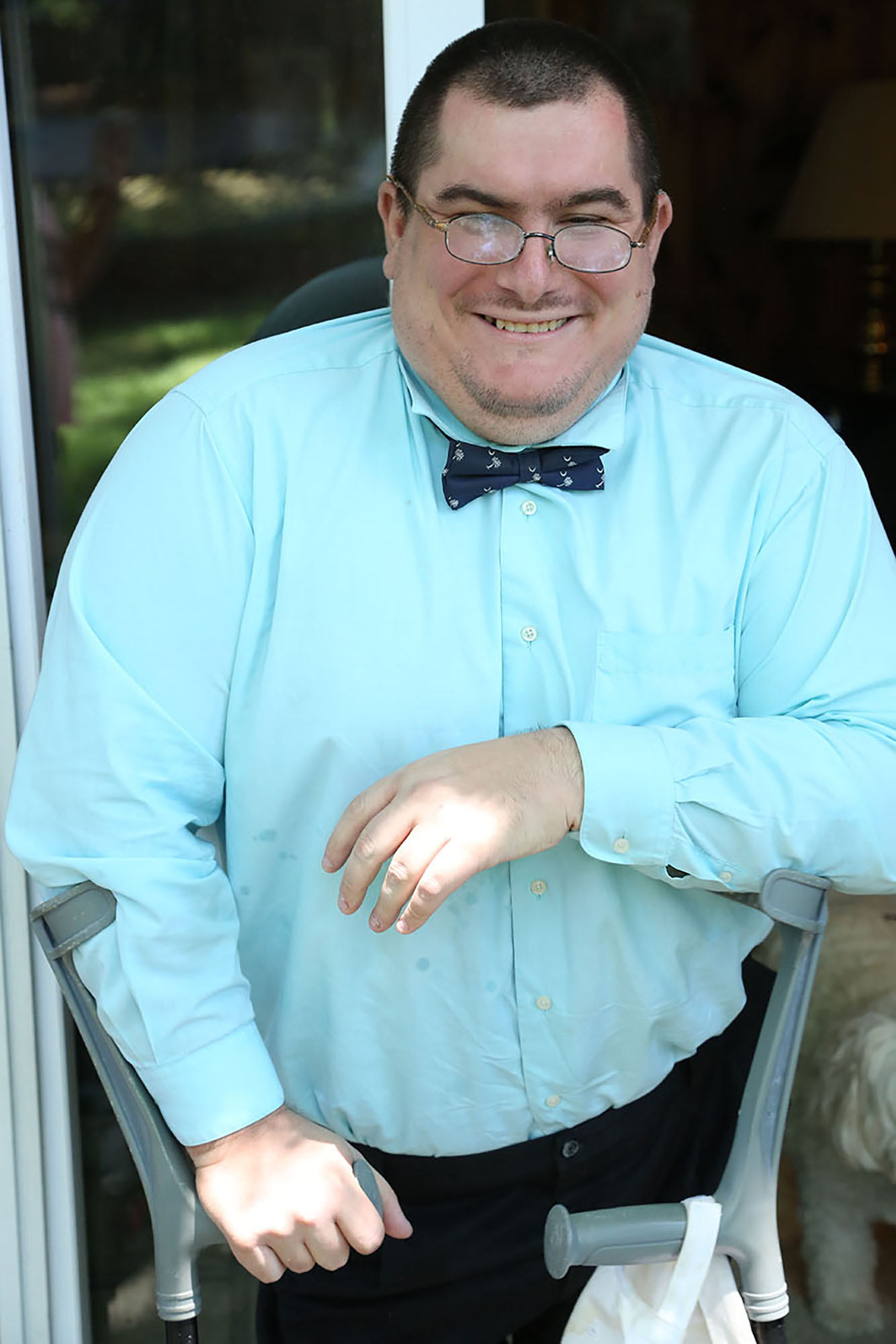Man with Sacral agenesis caudal regression wearing blue dress shirt looking at camera