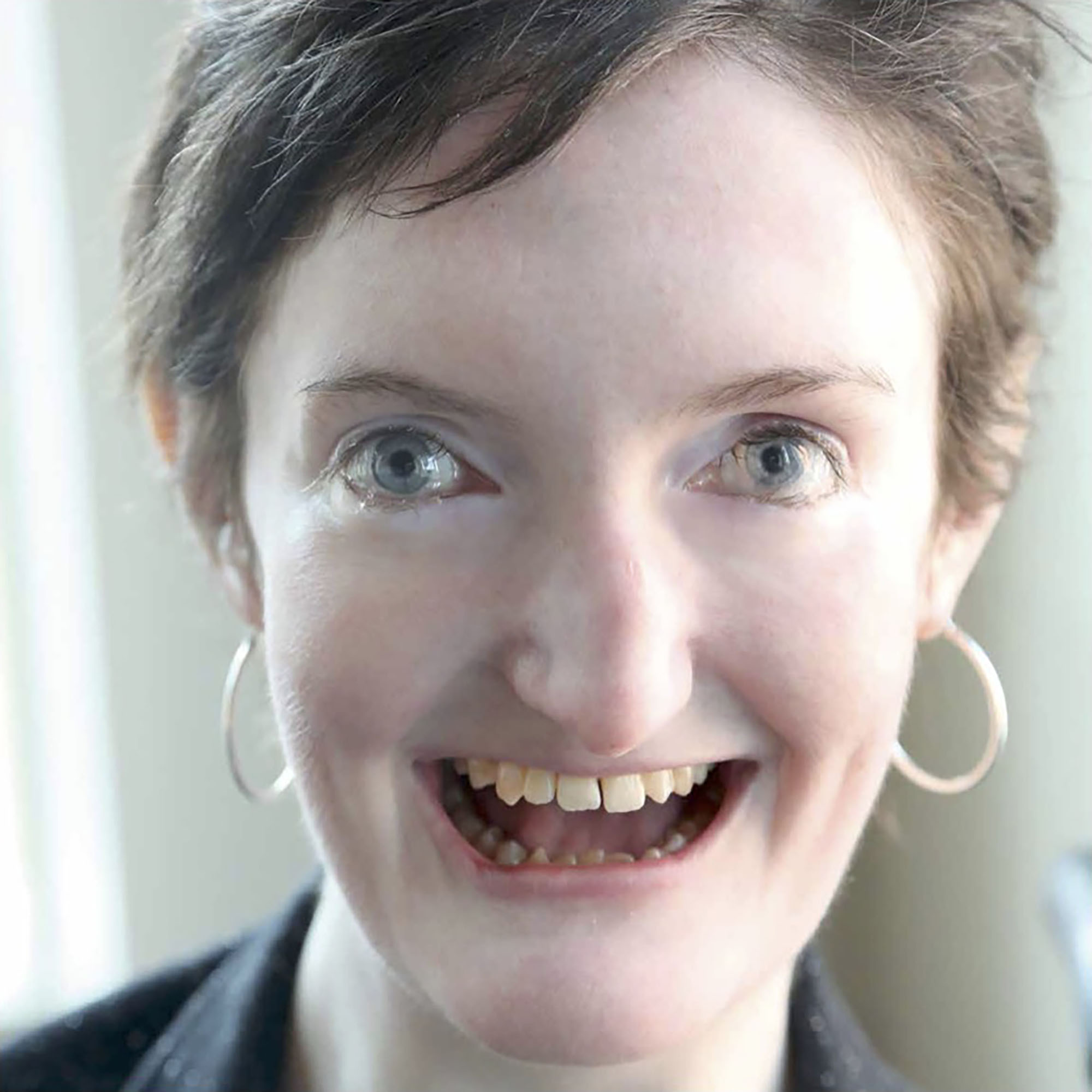 Woman with Familial Dysautonomia looking at camera, smiling.