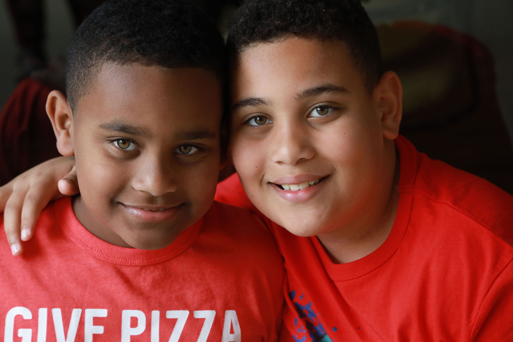 Two young brothers, one with autism hug and smile for the camera