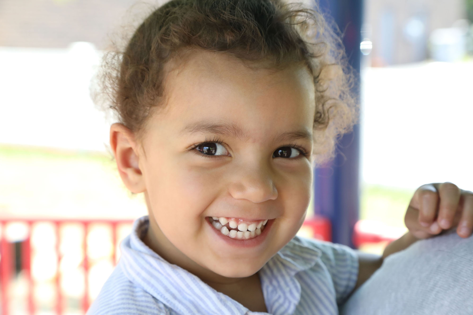 young girl with Autism smiles at the camera