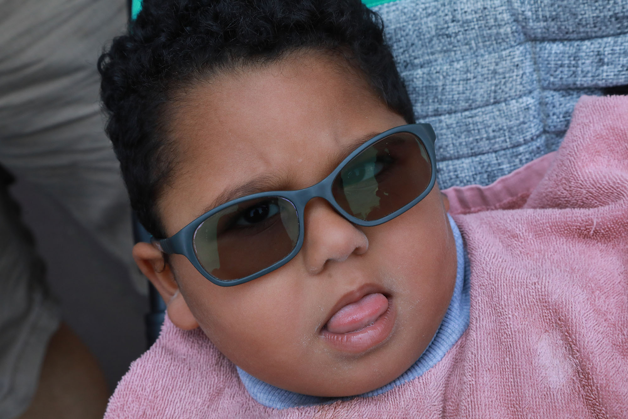 Young girl with grey sunglasses looking into the camera, closeup photo