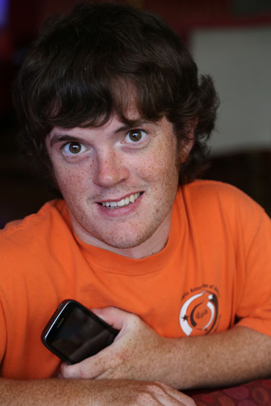 boy with skeletal dysplasia wearing orange shirt looking into the camera