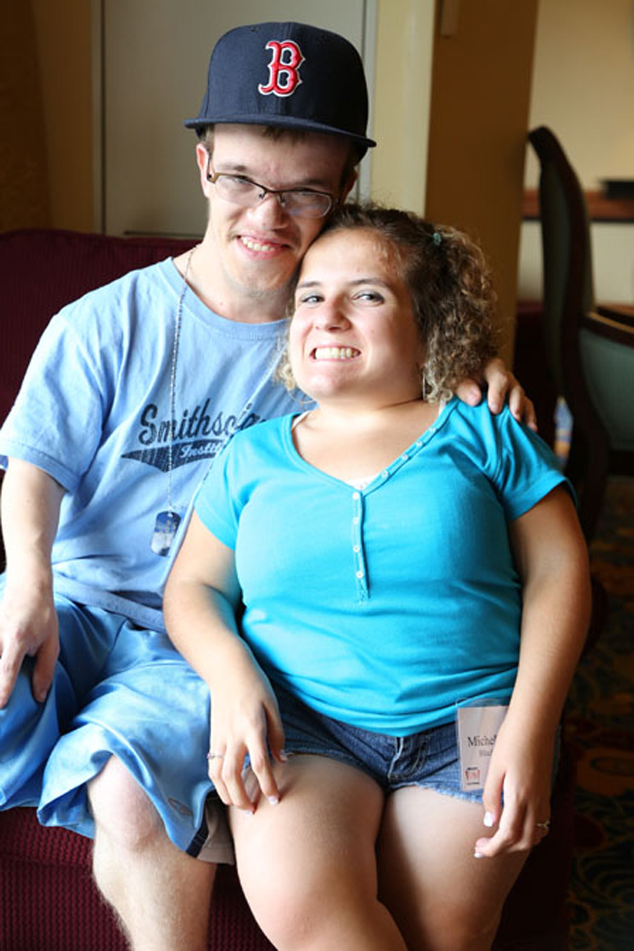 young couple with skeletal dysplasia sit down together, smilling