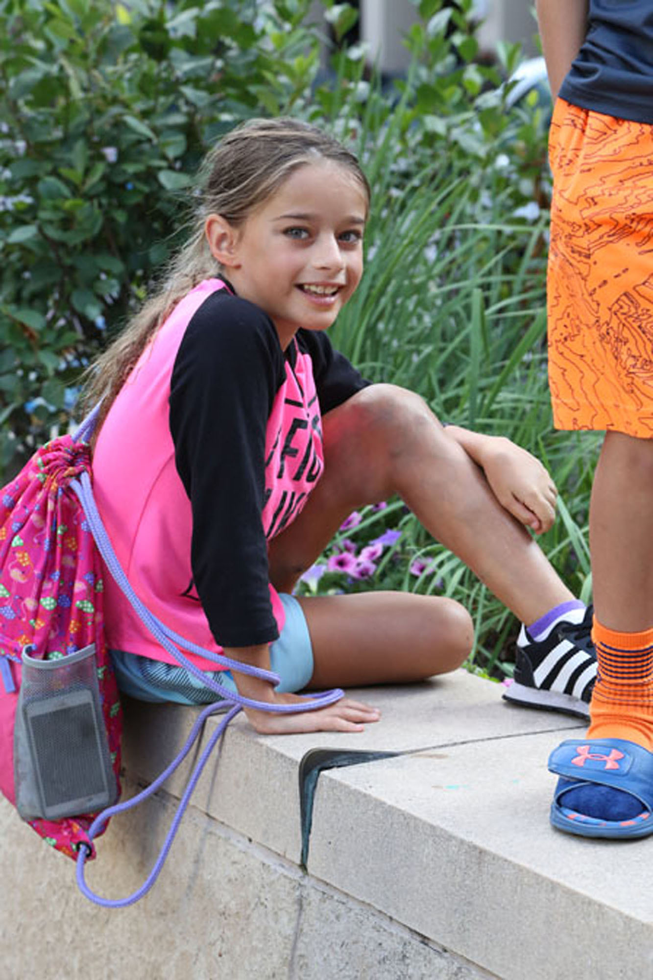 young girl with klippel trenaunay syndrome sitting down and smiling at the camera