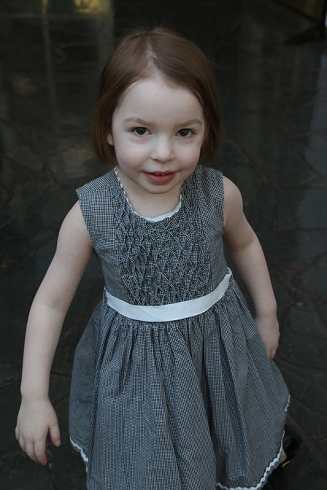 young girl with dravet syndrome wearing grey dress
