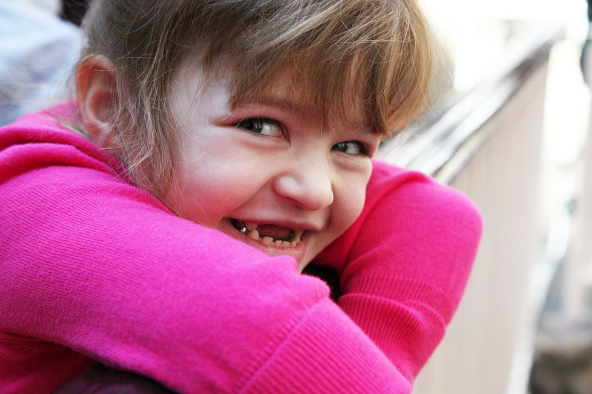 young girl with dravet syndrome wearing pink shirt smiling at camera