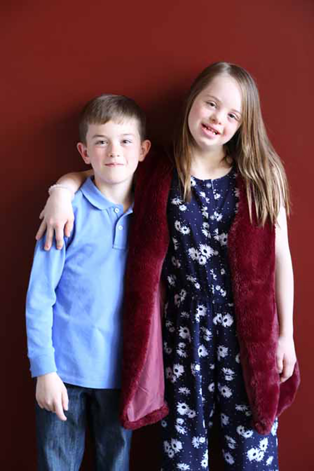 Young girl with down syndrome poses with her brother