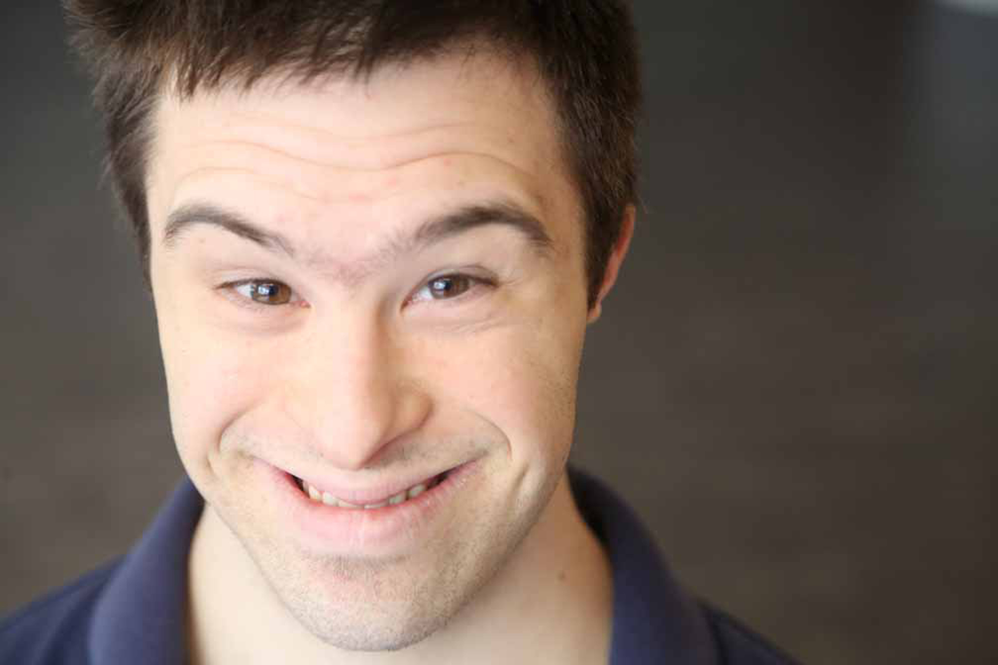 man with down syndrome smiling big at camera