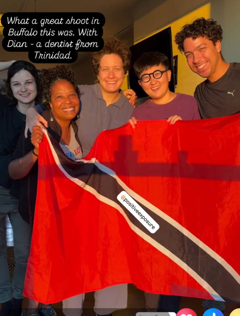 5 people in sunlight, holding a red flag 