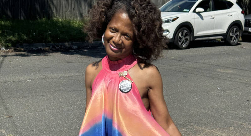 Woman with brown curly hair in a bright multicolored dress