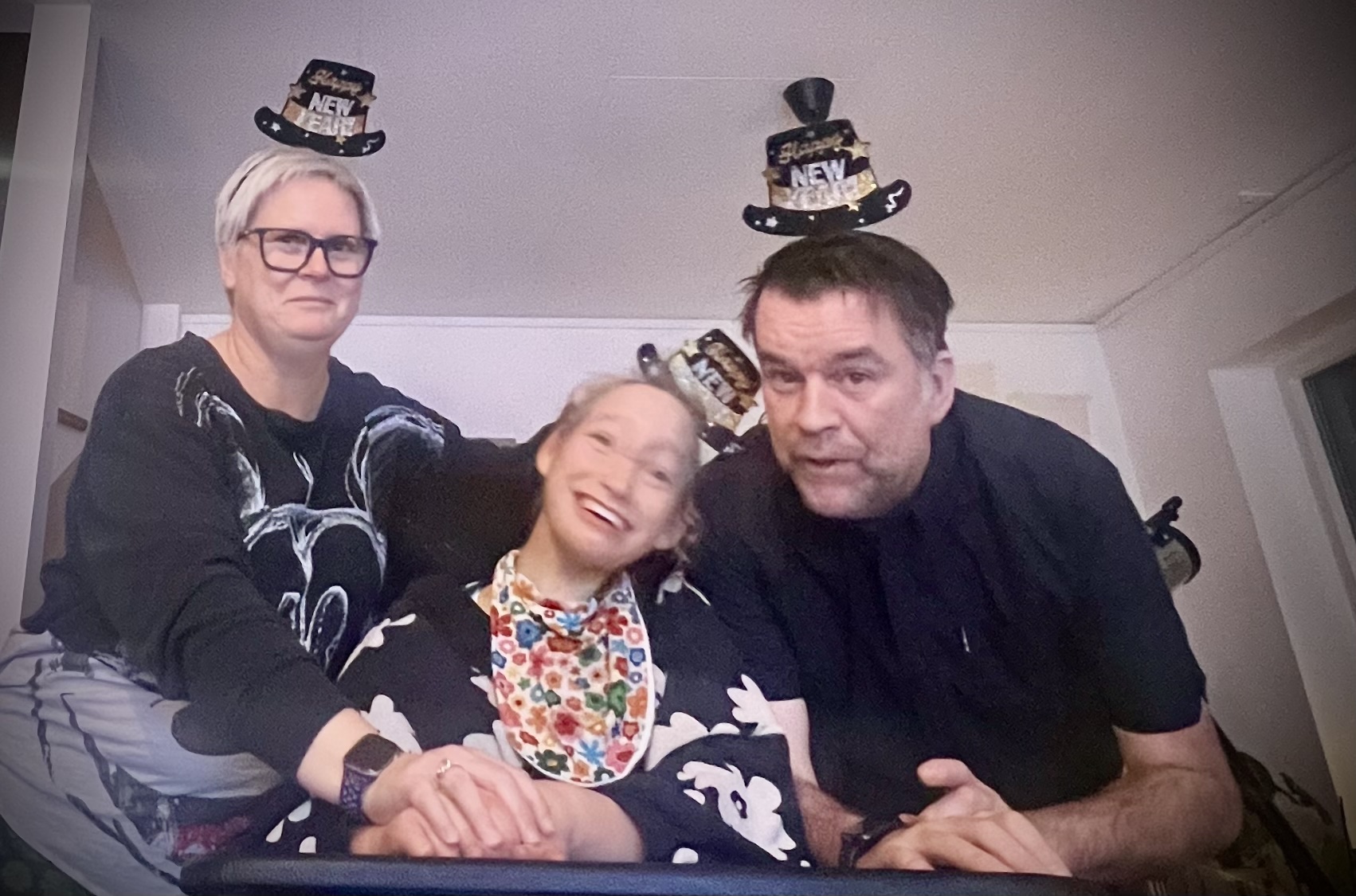 Mom, Dad and Freya all together wearing party hats..