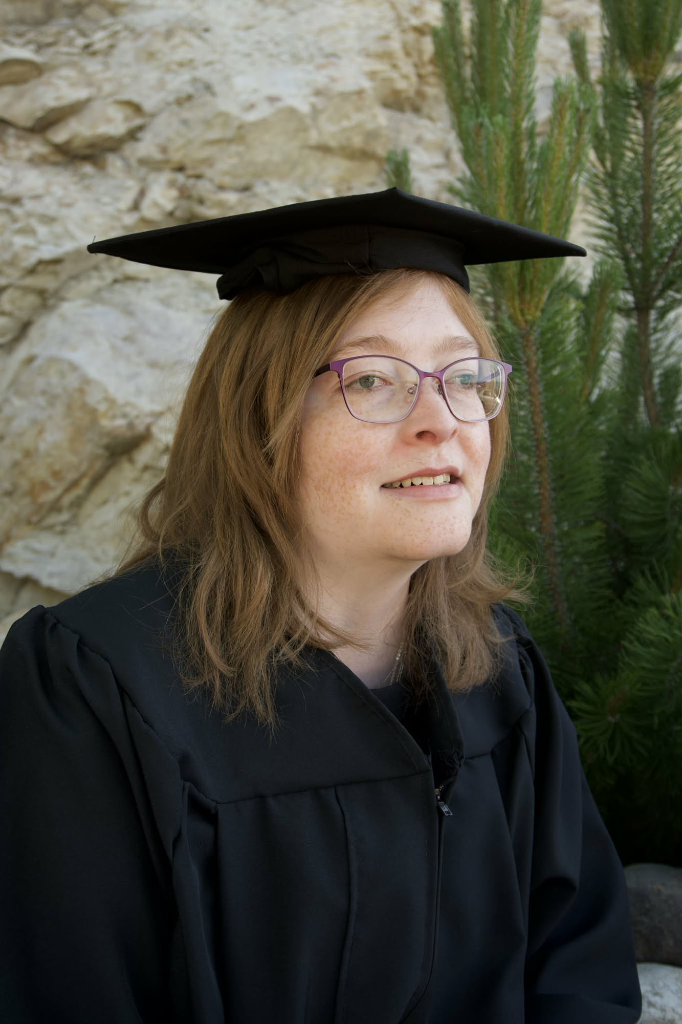 Me in a grad grown Young woman in black graduation cap and gown.