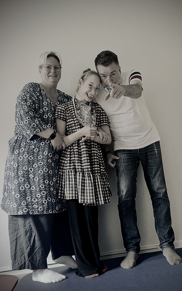 Young woman smiling and stnding between a man and woman (Mom and Dad)
